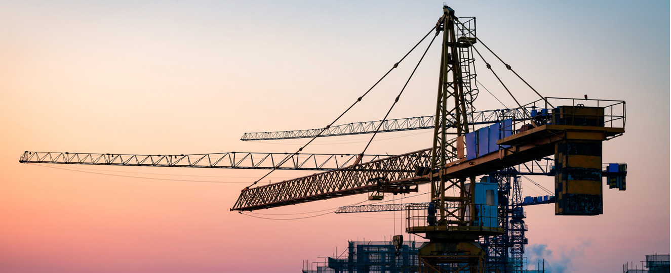 Construction crane with sunset in the background