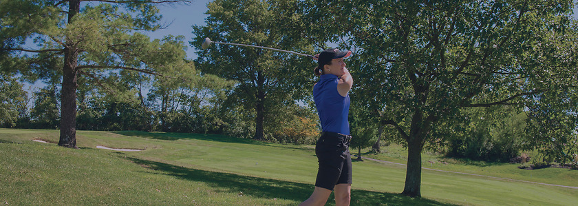 Susan Argo swings a golf club on the green.