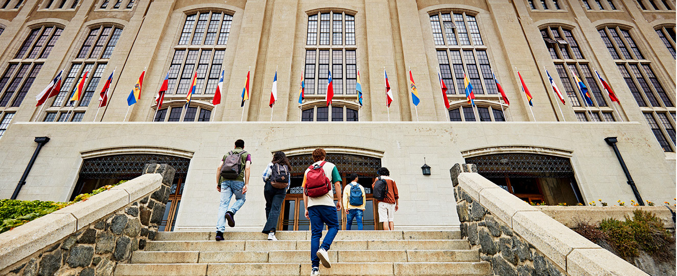 Students with back packs walking into a building