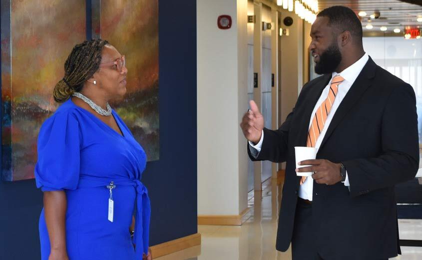 Two people standing in a lobby engaging in conversation