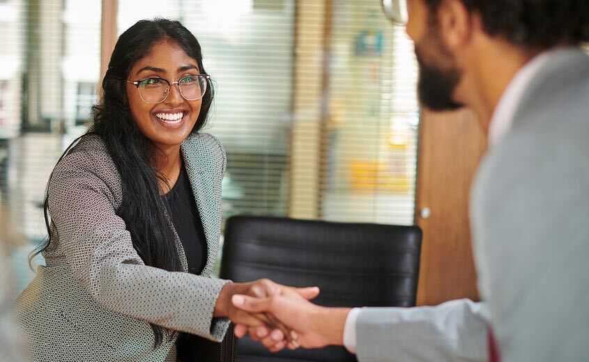 smiling woman shaking hands with a man