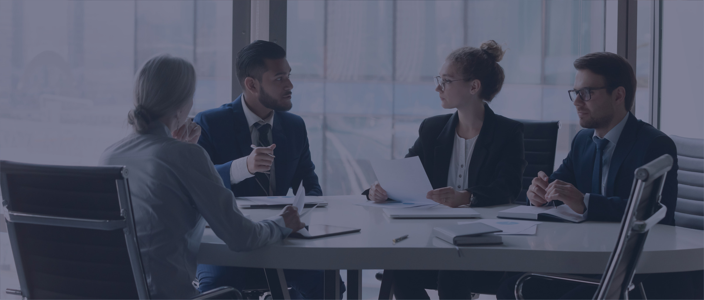 Four people sitting at a table reviewing paperwork