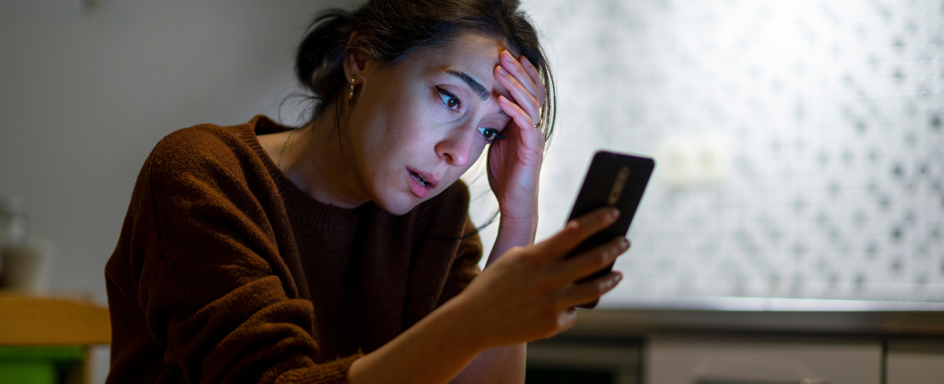 Woman looking at mobile phone looking upset