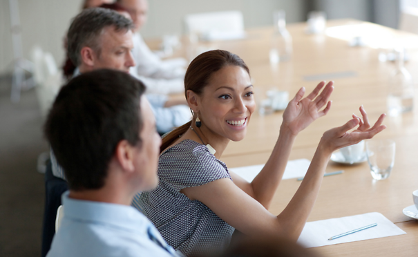 Smiling businesswoman gesturing in meeting in conference room