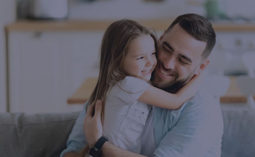 Adult and child hugging and smiling