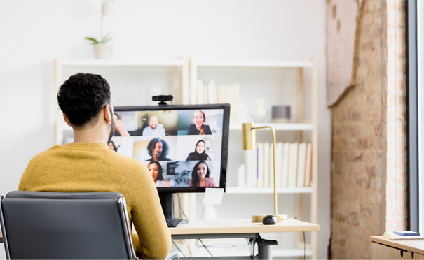 Person sitting in front of computer meeting with a group virtually