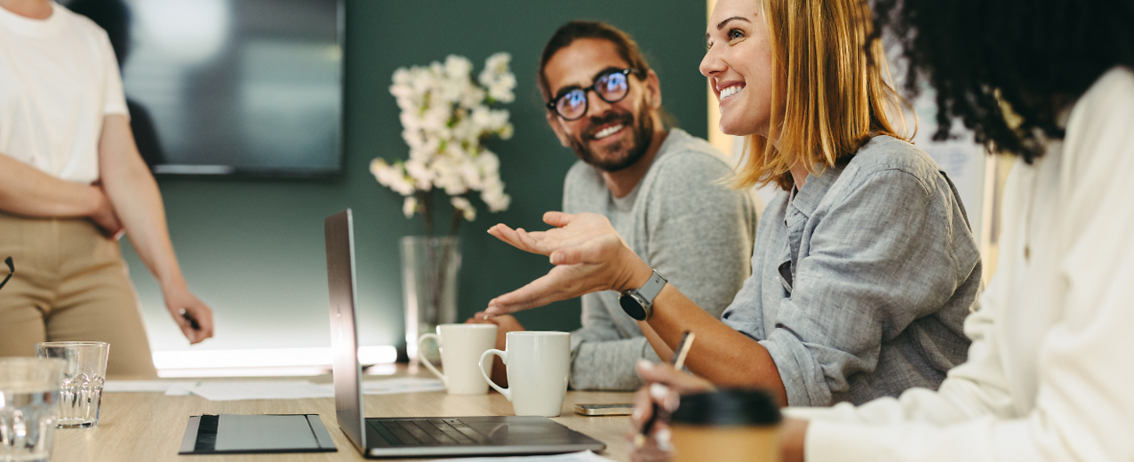 People talking at a table and working together in an office.