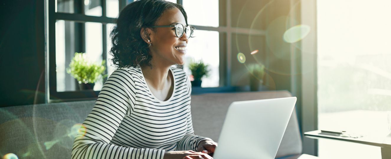 Smiling person working online with her laptop