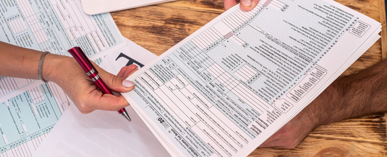 wo employees at work fill out tax forms 1040 at the office desk