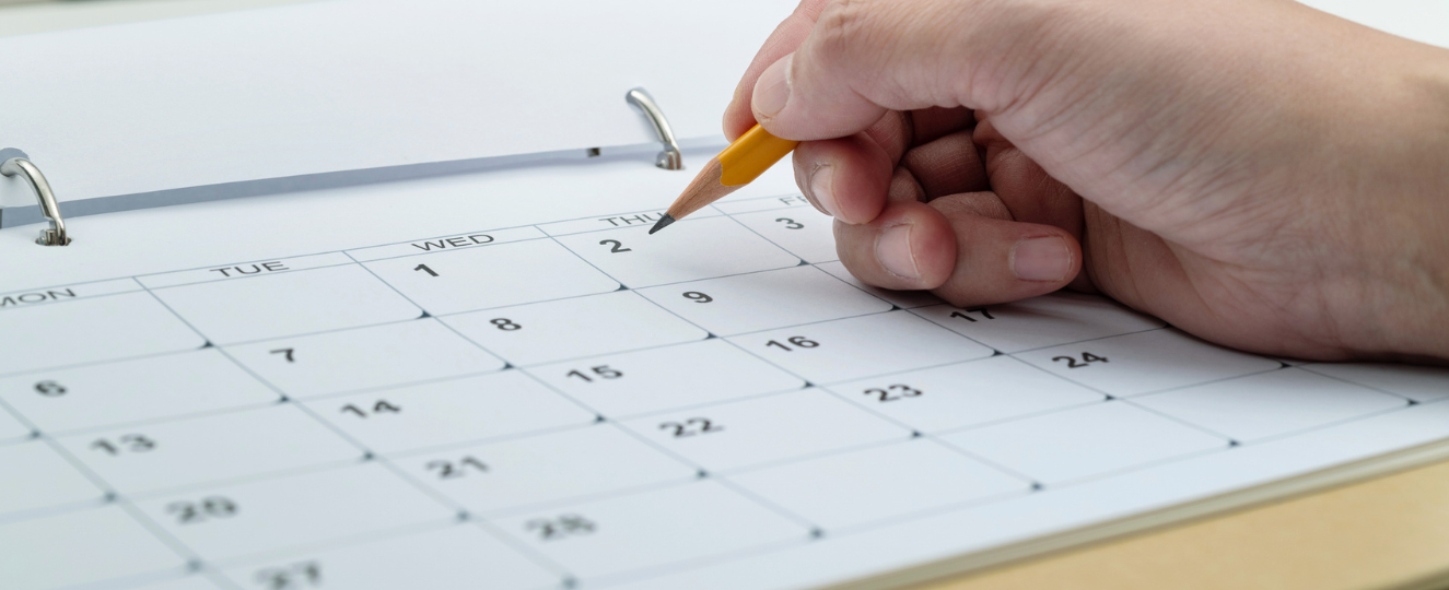 Calendar with a person circling a date with a pencil