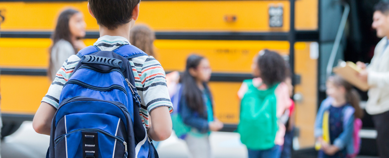 Young kid waits to load school bus