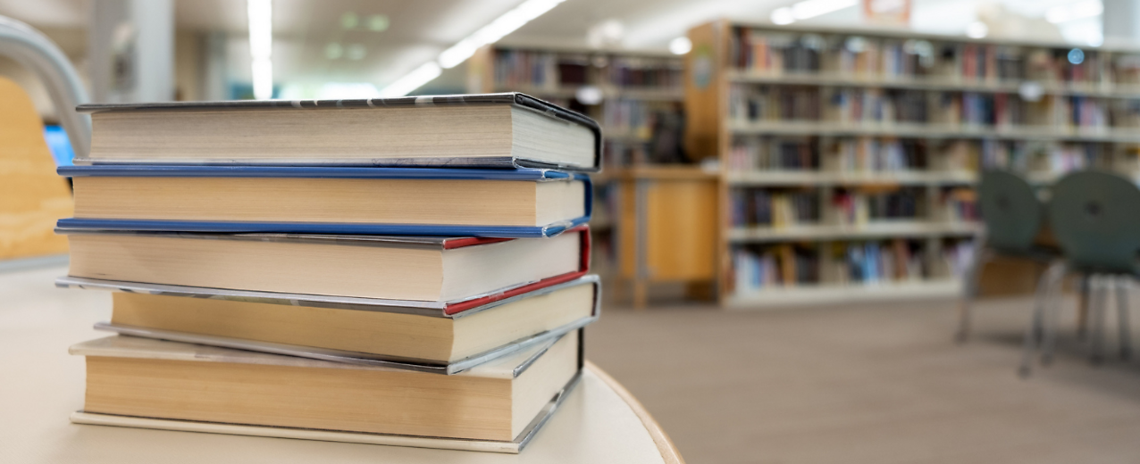 Stack of books on table at library